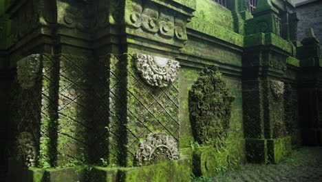 old built structure with mossy carvings in alas harum bali in tegallalang, indonesia