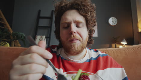 hombre comiendo ensalada en casa