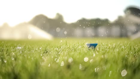 golf club hits a golf ball in a super slow motion. drops of morning dew and grass particles rise into the air after the impact.