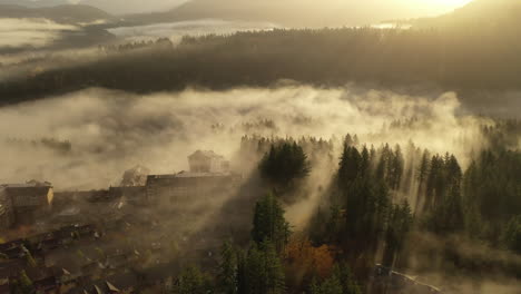 4k-Luftaufnahme-Der-Morgensonne,-Die-Durch-Den-Dichten-Nebel-über-Der-Verschlafenen-Stadt-Scheint