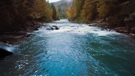 low flight over the mountain river, blue in the middle of the forest and mountains. sunset time. the sun's rays give orange flare. the concept of curing urological diseases and prostatitis