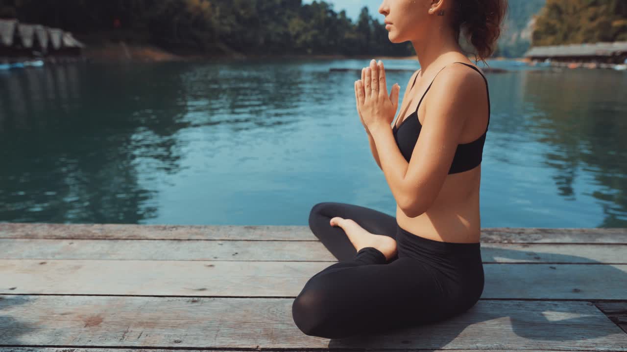 Mujer meditando junto al lago