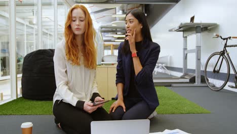 Female-executives-discussing-over-laptop-4k