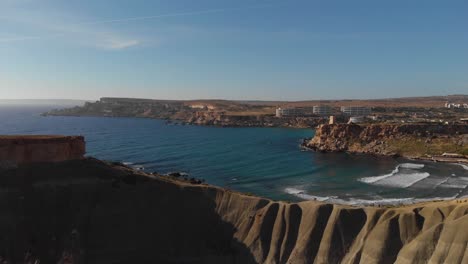 aerial: beautiful coast of malta with rock formations next to ghajn tuffieha bay