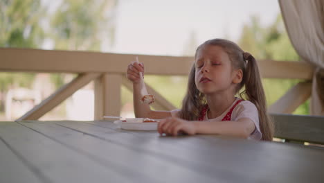 Little-girl-eats-cottage-cheese-pancake-in-restaurant