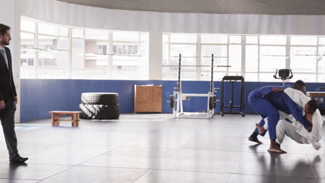 athletes practicing judo techniques in gym, demonstrating strength and agility
