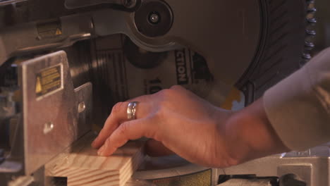 close up of wood cutting machinery hand cutting wood in a workshop with a wood clamp and saw