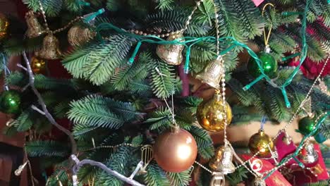 close up shot of a plastic christmas tree fully decorated with christmas balls, bells, cards, and christmas light