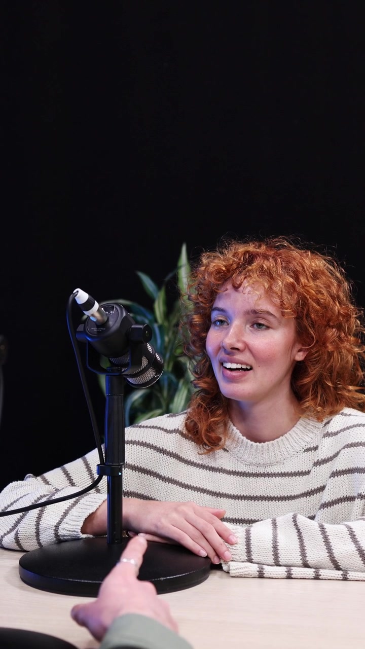 Young Woman with Curly Red Hair Talking During a Podcast Interview