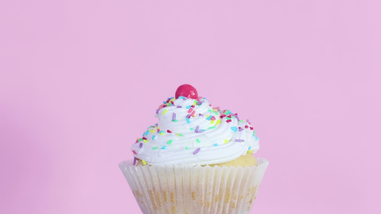 Slowly rotating one cup cake with cream on pink theme