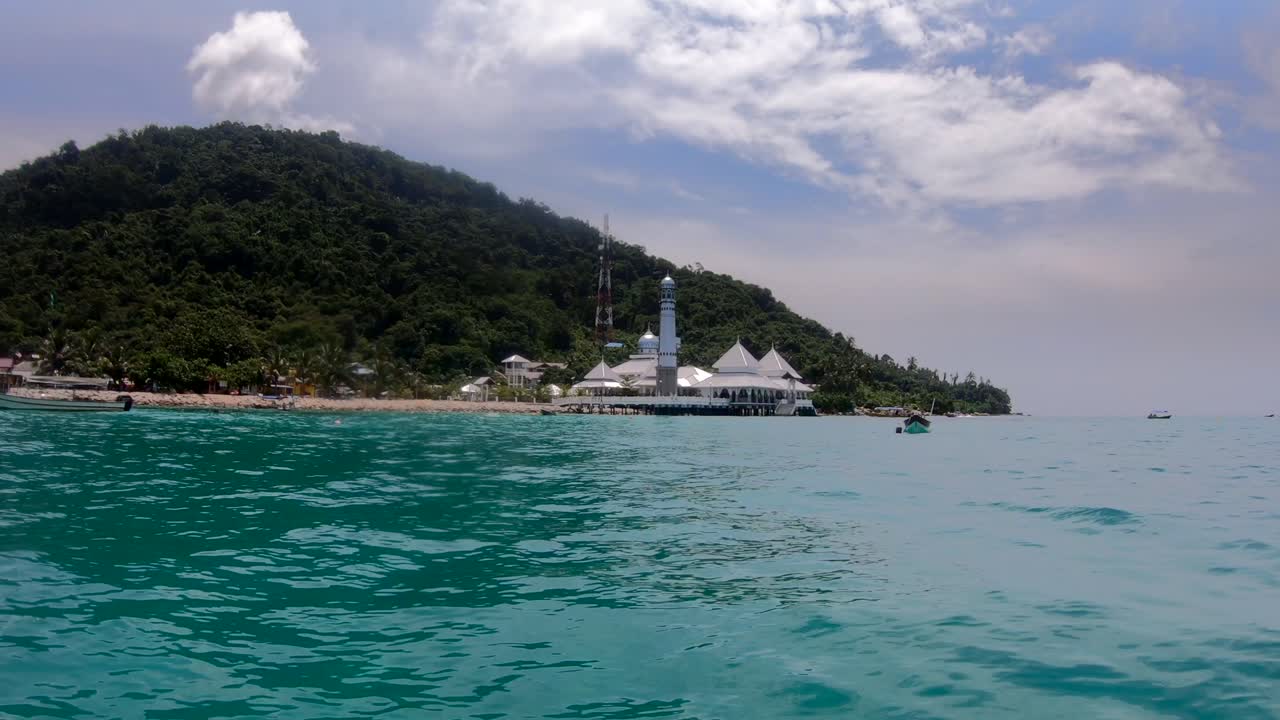 Floating mosque, religious building on the blue ocean in Malaysia, Perhentian Island. Popular travel destination, boat view.