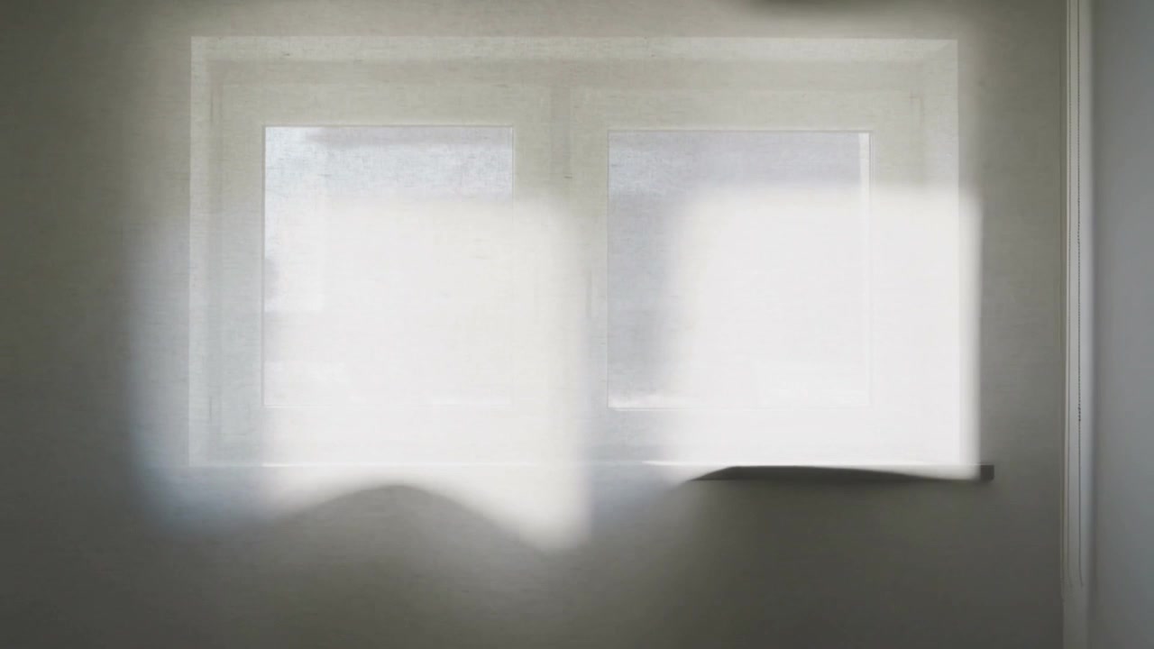 Luce solare cangiante che scivola attraverso una finestra a doppio vetro in una stanza mentre il sole si sposta, proiettando chiazze luminose.