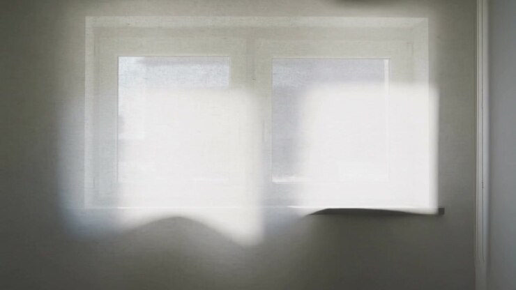 Shifting sunlight slipping across double-pane window in room as sun shifts casting bright patches