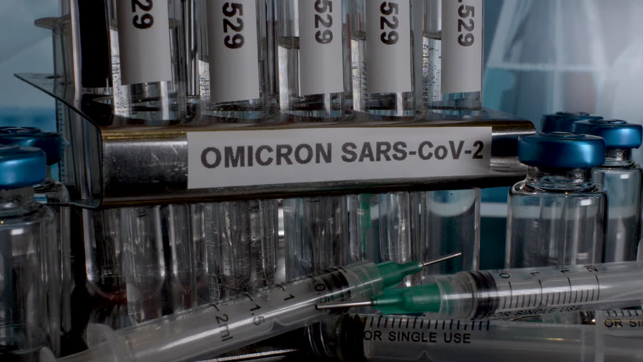 Omicron Sample Test Tubes Being Removed From Rack Next To Empty Vial Bottles And Syringes. Static, Close Up