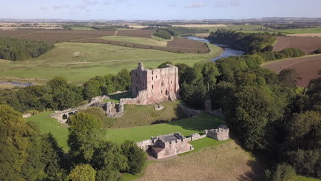 Aerial-view-of-Norham-Castle-ruin-on-a-sunny-day,-Northumberland,-England