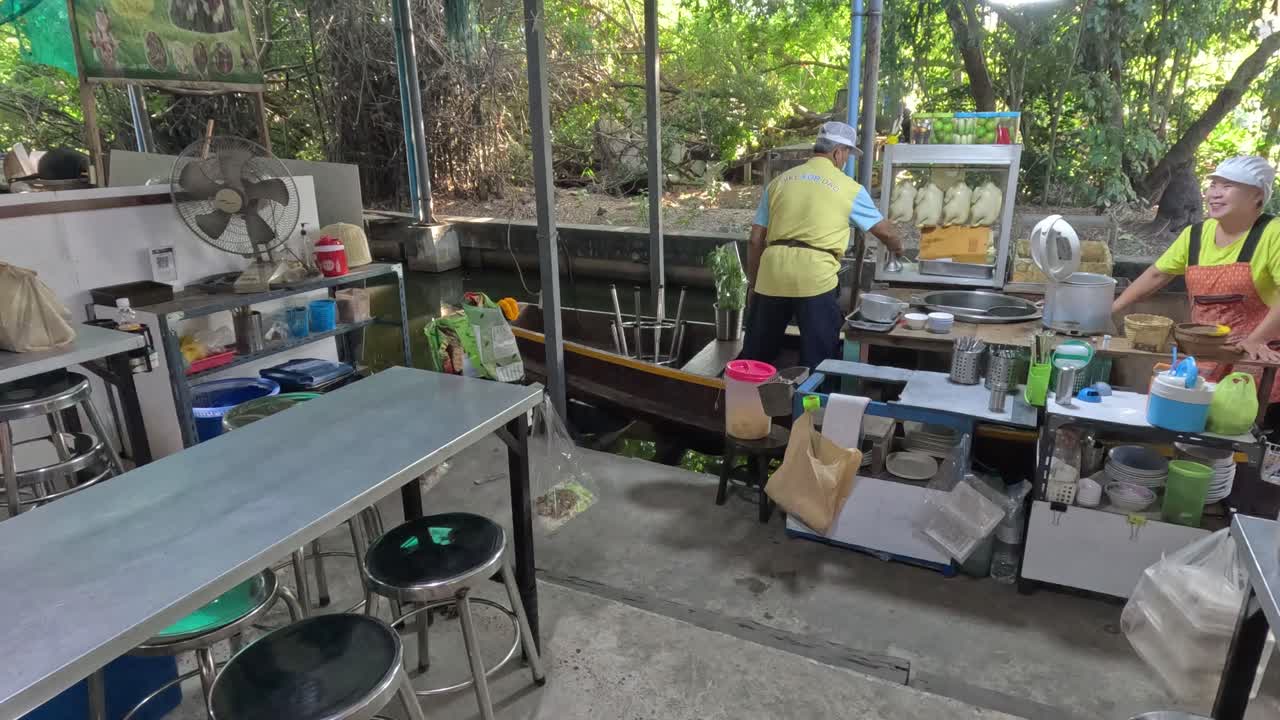 trabajadores preparando comida en un puesto de fideos ocupado