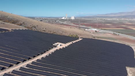 revelando aviones no tripulados parque de energía solar fotovoltaica fila de paneles de granja planta de energía de carbón fondo