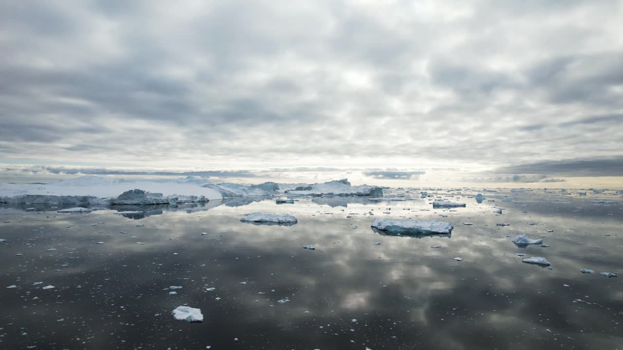Sunny northland sky and icebergs floating near Greenland, aerial view
