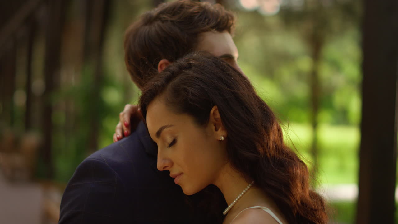 사랑하는 커플이 공원에서 춤을 춘다. 신부는 결혼식에서 신랑의 어깨에 머리를 고 있다.