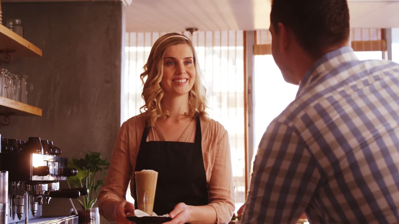Waitress giving a glass of cold coffee to customer
