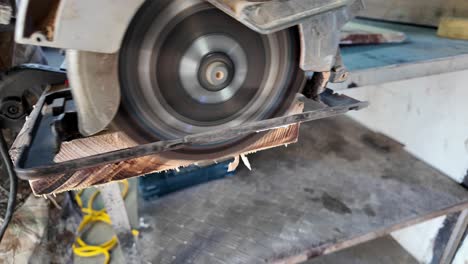 close-up of circular saw actively cutting through a piece of wood, generating sawdust