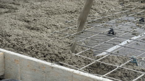 CLOSE UP Wet Cement Poured Over Wire Mesh On New House Slab