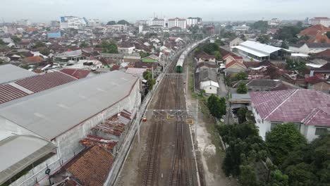 Vista-Aérea,-El-Tren-Que-Corre-Lentamente-Comienza-A-Salir-De-La-Estación-De-Lempuyangan-Yogyakarta-Y-Muestra-Una-Vista-De-La-Ciudad-De-Yogyakarta