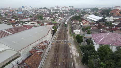 vista aérea, el tren que corre lentamente comienza a salir de la estación de lempuyangan yogyakarta y muestra una vista de la ciudad de yogyakarta