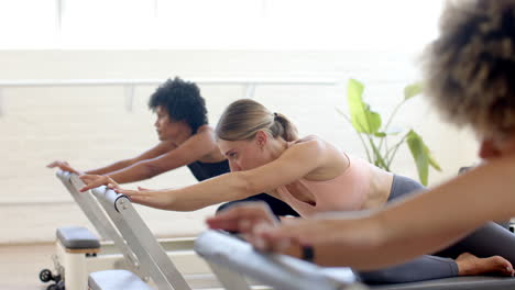 diverse group of friends practicing pilates in bright studio