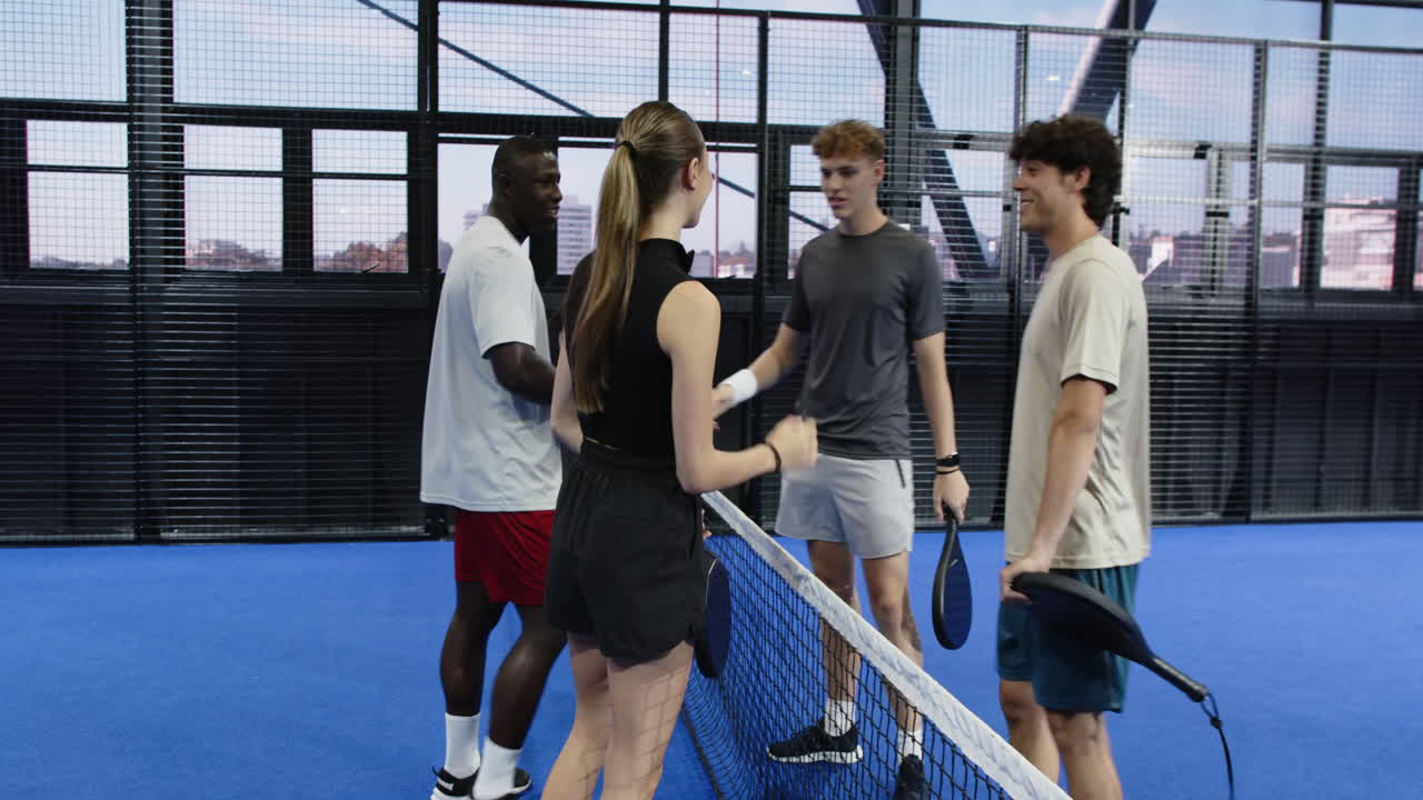 Young woman playing padel tennis on blue court, preparing to return serve