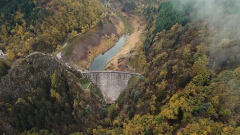 Toma-Aérea-De-Una-Presa-A-Través-De-Nubes-Y-Niebla,-Presa-Gouffre-D&#39;enfer-En-Francia-Cerca-De-Saint-Etienne-Durante-El-Otoño,-Departamento-De-Loira,-Francia