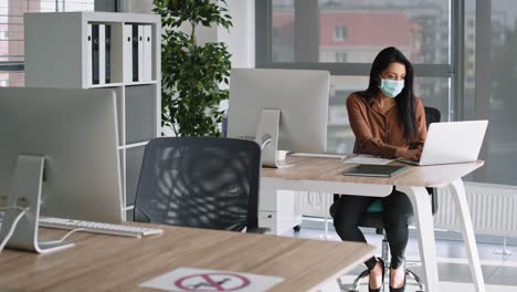 tracking video of women in protective mask working in office