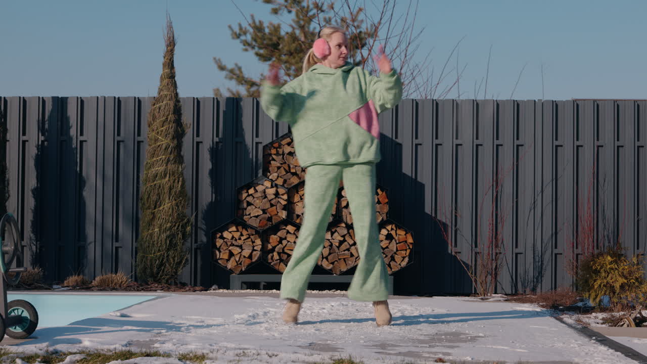 여자 는 겨울 정원 에서 춤 을 추고 고 있다