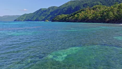 Aerial-flyover-coral-reef-in-clear-Water-with-exotic-coastline-in-Summer