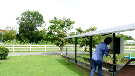 agronomist farmer using tablet to monitor solar cell for pumping water in farm. power management in agriculture using mobile apps technology