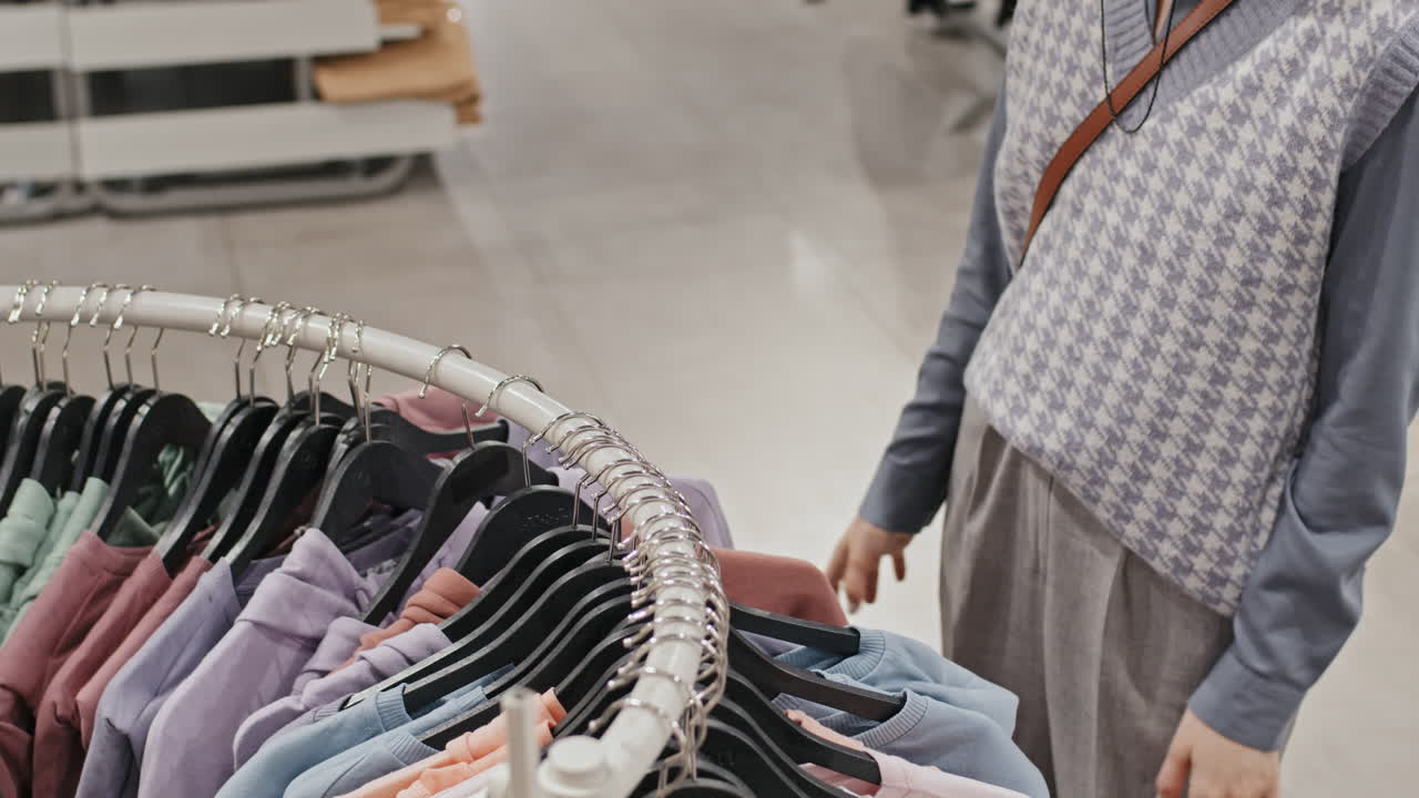 Woman Selecting Hoodie In Clothing Store