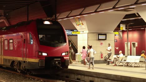 people boarding a red train at turin station