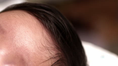 close-up shot of a newborn baby's forehead while it is sleeping so soundly inside her soft and comfortable bed