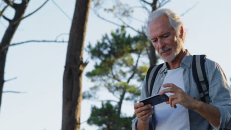 senior man clicking photos with mobile phone at countryside 4k