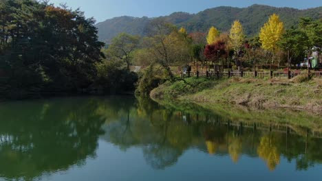 clean forests and mountains that reflect on clear green waters