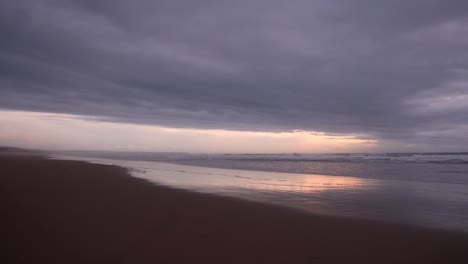 Puesta-De-Sol-Tranquila-Y-Relajante-En-La-Playa-Con-Reflejos-Coloridos,-4k