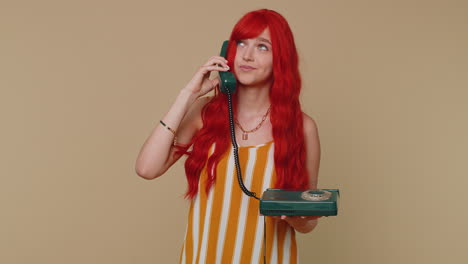 Crazy-redhead-girl-talking-on-wired-vintage-telephone-fooling,-making-making-playful-silly-faces