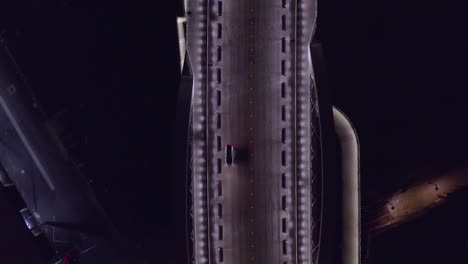 down facing aerial view of 6th street bridge in downtown los angeles at night with cars passing below