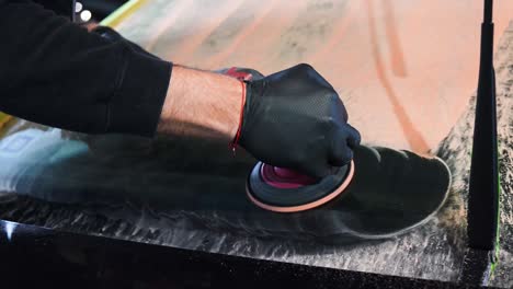 car detailing and cleaning young male car worker, wearing black gloves.