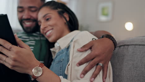 happy couple, tablet and hug on sofa in home
