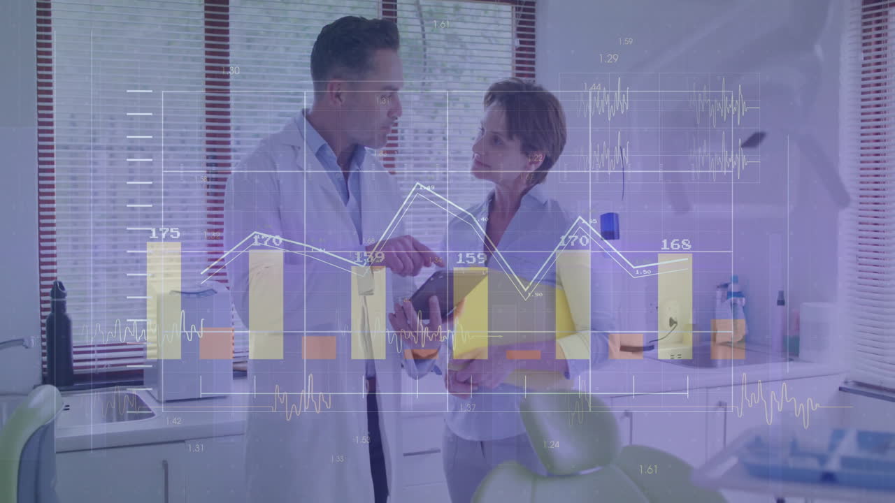 Doctor reviewing tablet data with colleague in medical clinic, showing charts and waveforms