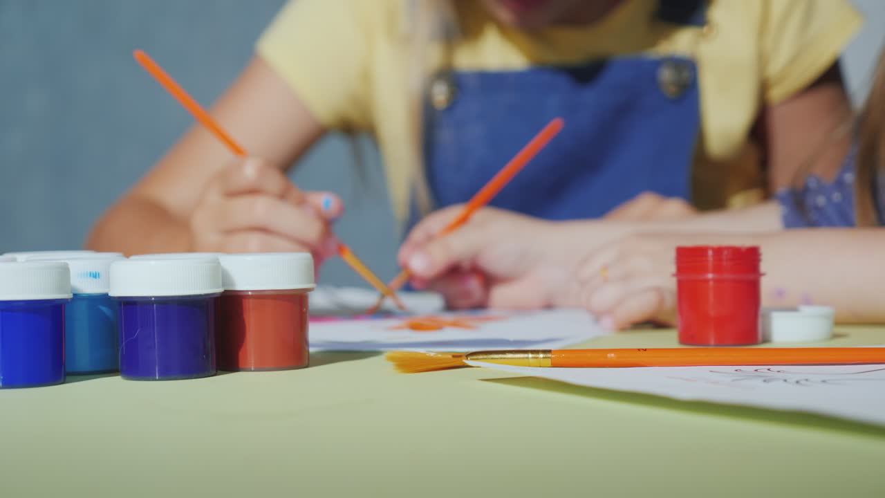 manos de niños con pinceles pintan con acuarelas video 4k