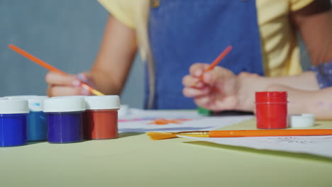 children's hands with brushes paint with watercolors 4k video