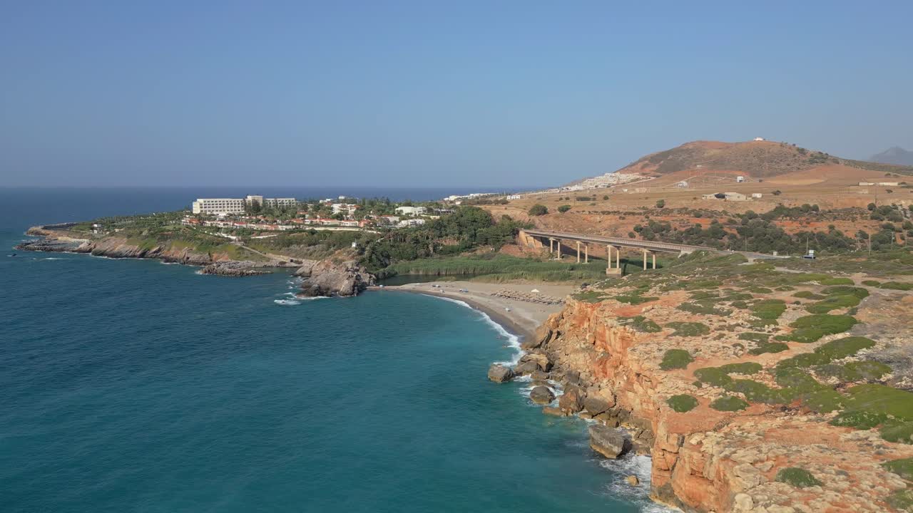 Cinematic footage of Geropotamos coastline and beach in Crete, with the iconic bridge in the background over the blue sea
