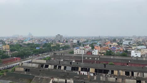vista aérea épica de la magnífica ciudad de kolkata con vía férrea, antiguas fábricas cerradas y tren en movimiento